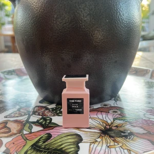 Tom Ford Rose Prick Eau de Parfum - Säljer en exklusiv Tom Ford Rose Prick Eau de Parfum i en snygg ljusrosa flaska på 7,5 ml. Flaskan har en stilren, fyrkantig design med svart etikett och lock. Perfekt för dig som gillar lyxiga och unika dofter med ros som huvudtema.