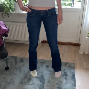 Blå lågmidjase bootcut jeans från Levi's - Säljer dessa jättesnygga lågmidjade bootcut jeansen från Levi’s! Midjemåttet rakt över är 40-41cm, innerbenslängden är ca 81 cm och grenhöjden är ca 16cm. Jeansen har sytts mer lågmidjade från förra ägaren. De har inga defekter. Skriv för frågor och funderingar! 💞😊