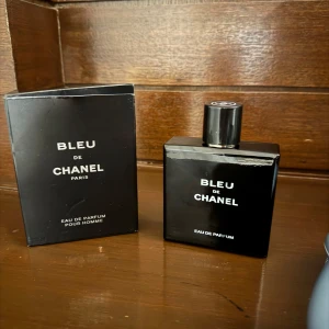 Bleu de Chanel Eau de Parfum - Bleu de Chanel Eau de Parfum för herrar. Flaskan är elegant och fyrkantig i djupsvart glas med vit text och klassisk Chanel-logga på korken. Kommer med originalkartong i matchande svart design. En ikonisk och modern doft från Chanel.