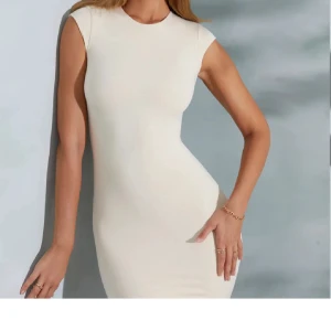 Oh polly miniklänning - Supersnygg vit kortklänning i figurnära modell med rund hals och cap sleeves. Klänningen har en öppen rygg. Aldrig använd.