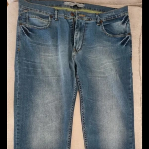 Blå jeans från Diesel, storlek 36 - Snygga blå jeans från Diesel helt nya i klassisk femficksmodell. Jeansen har ljus tvätt med slitningar och kontrastsömmar, samt läderpatch med Diesel-logga bak. Tillverkade i jeansmaterial och passar perfekt till en avslappnad stil.