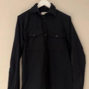 Jack o jones overshirt - Jack o jones overshirt endast använd en gång  Stilren overshirt med klassisk krage och två stora bröstfickor med knappar. Långärmad modell som passar perfekt över en t-shirt. Enkel och clean design som funkar till många olika looks.