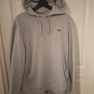 Lacoste hoodie - Grå lacoste hoodie storlek XL men sitter som L, äkta, använd fåtal gånger, nypris: 1400kr mitt pris 649kr, pris går att diskutera💸