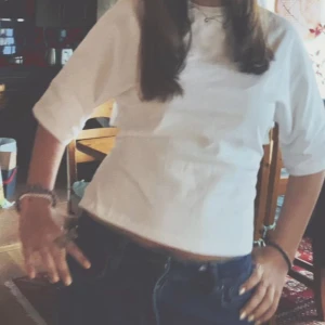 Vit omlottopp med knyt i ryggen - Säljer en vit omlottopp med trekvartsärm och snygg knytning i ryggen. Toppen är croppad och har en stilren, enkel design som passar perfekt till jeans eller kjol. Gjord i ett lätt och skönt material som känns luftigt. Från Nelly 