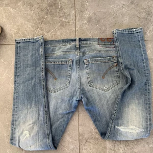 Ljusblå skinny jeans med slitningar - Säljer ett par ljusblå skinny jeans med snygga slitningar på benen och klassiska bakfickor. Jeansen har en smal passform och är tillverkade i stretchig denim för en bekväm känsla. Perfekta för dig som gillar en modern och avslappnad stil. Dm för frågor🙌