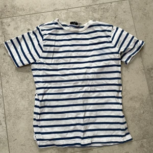 Randig t shirt - Säljer denna vita och blå randiga t shirt från NAKD i storlek XXS. 50 kr+ frakt 