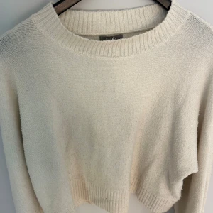 Beige stickad tröja från Lindex - Mysig beige stickad tröja från Lindex i storlek S. Tröjan har en klassisk rund halsringning och ribbade muddar vid hals, ärmslut och nederkant.
