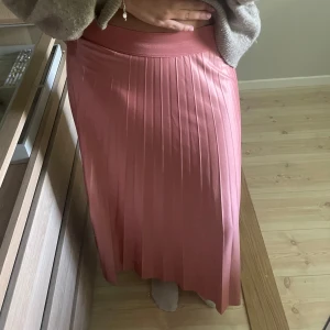 Plisserad rosa långkjol - Säljer en superfin plisserad långkjol i en härlig rosa nyans. Kjolen har bred resår i midjan.Den sitter lite kort på mig som är 165 men de är en smaksak.Pris går att diskutera💕