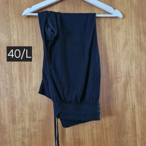 Svarta mjukisbyxor med snörning L - Svarta mjukisbyxor i storlek L med resår och snörning vid bensluten. Perfekta för chill dagar eller när du vill vara extra bekväm. Tillverkade i mjukt material som känns skönt mot huden.