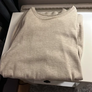 Beige tröja från Kappahl - Säljer en stilren beige tröja från Kappahl i storlek S. Tröjan har en klassisk design med rund hals och är perfekt för en avslappnad look. Stickad Hoodie riktigt skön nu till våren när man vill bara väst