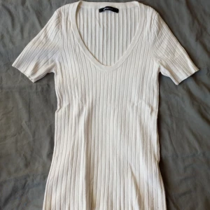 Vit V-ringad T-Shirt  - Säljer denna vita V-ringade t-shirten ifrån Gina Tricot. Köparen står för frakten! 