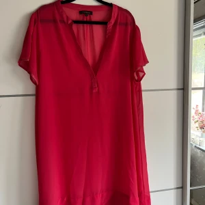 Rosa klänning från Alice Bizous - Säljer en snygg rosa klänning från Alice Bizous. Den har en v-ringad design och korta ärmar, perfekt för en somrig look. Klänningen är i ett lätt och luftigt material som ger en skön känsla.