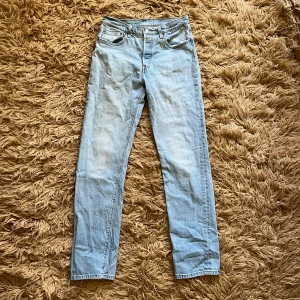 Ljusa jeans från Levi's - Säljer ett par ljusa och raka Levi's jeans. Det är små bleka rosa fläckar på ena knät och sedan rester av broderingar som tagits bort (finns bild). Annars är dom i fint skick. W28 L32
