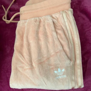 Aprikos mjukisbyxor/tröja från Adidas - Säljer ett helt adidas sett för 350kr. Använd ett par fåtal gånger bara, så nästan nytt. Storlek 34 både tröja och byxor 