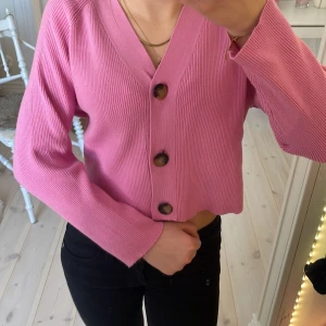 Rosa ribbad kofta från Zara - Säljer en rosa ribbad kofta från Zara med stora knappar framtill. Koftan har en v-ringad design och långa ärmar. Använd ett fåtal gånger och är perfekt till våren och sommaren!💓Köpt i Köpenhamn🫶🏼