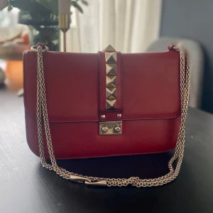 Valentino Garavani Glam lock medium - Jättefin Glam lock från Valentino Garavani.  Använt med fint skick. Köpte den begagnad, har därför inget kvitto, dock finns både dustbag och såklart koden i väskan.   Kan se om jag kan få till en autentisering på något vis, alternativt att jag kan sälja genom Vestiaire eller så kan jag mötas upp vid Valentino om man vill få äktheten garanterad.
