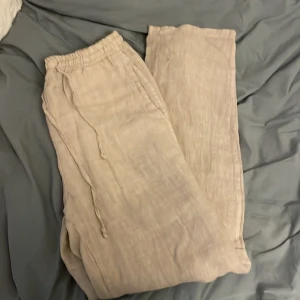 Beige linnebyxor från Chelsea Girls - Snygga beige linnebyxor från Chelsea Girls, tillverkade i Italien. Byxorna har en avslappnad passform med elastisk midja. Perfekta för en stilren och bekväm look. Aldrig använda och tyvärr för små så där av säljer jag.