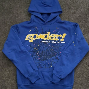 Spider Punk Blå hoodie - Snygg blå hoodie med en cool spindelnätsdesign och texten 'spider!' i gult på framsidan. Perfekt för en avslappnad stil med en touch av unik design. Hoodien har långa ärmar och en klassisk huva.