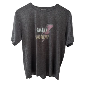  Saint Laurent - Snygg grå t-shirt från Saint Laurent med ett coolt tryck i vitt och rosa på framsidan. Perfekt för en avslappnad stil med en touch av lyx. T-shirten har en normal passform och korta ärmar.