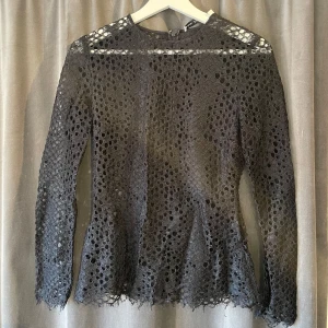 Svart spetsblus från & Other Stories - Säljer en elegant svart spetsblus från & Other Stories. Blusen har ett vackert hålmönster och långa ärmar. Perfekt för att ge en stilfull touch till din outfit. Dragkedja baktill för enkel påklädning.⭐️
