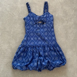 Blå mönstrad klänning från Zara - Säljer en söt blå klänning från Zara med ett vitt blommönster. Klänningen har en volangkjol och smockdetaljer på ryggen. Axelbanden är rynkade och det finns en liten öppning framtill. Perfekt till sommaren! 💙 ⚠️fri frakt⚠️