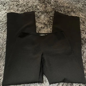 Svarta lågmidjade byxor från ONLY - Snygga svarta byxor från ONLY med en elegant och stilren design. Byxorna har en rak passform och är perfekta för en chic look. Tillverkade i ett mjukt och bekvämt material som ger en skön känsla hela dagen.