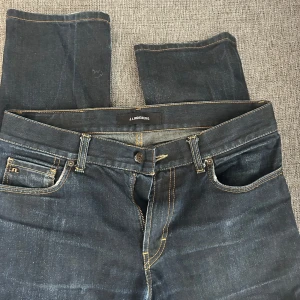 Mörkblå jeans från J.Lindeberg -  mörkblå jeans från J.Lindeberg.  tillverkade i slitstarkt denim. Perfekta för en stilren look.