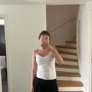 Svart kortkjol från H&M i bomull - Svart kortkjol från H&M i mjuk ekologisk bomull. Kjolen har en enkel, utsvängd modell med resår i midjan för skön passform. Perfekt att styla med en crop top eller hoodie för en chill look.