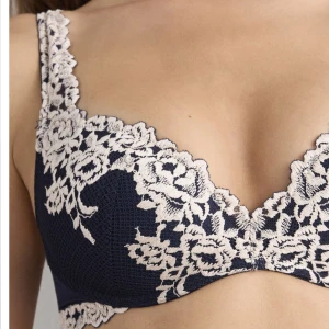 Intimissimi superpushup- bh Gioia pretty flowers - Supersnygg mörkblå bh utan bygel med ljus spets och blommigt mönster. Djup v-ringning och breda axelband, perfekt för att ge en romantisk vibe. Spetsdetaljerna ger en lyxig känsla och bh:n har en feminin form som framhäver siluetten.