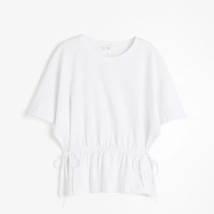 Vit topp med knyt i midjan H&M - Vit topp från H&M med korta ärmar och rund halsringning. Midjan har snygga knytband på sidorna som ger en cool och avslappnad look. Perfekt till jeans eller kjol för en enkel men trendig outfit.