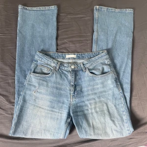 Blåa bootcut jeans - Säljer ett par blåa jeans från Gina tricot med bootcut passform. Jeansen är mid waist och har ett hål på ena benet samt lite slitage vid jeansens slut. Byxorna är även lite slitna mellan benen, men det är inte något som är sönder eller som man tänker på. Köpte för 399kr! Hör av vid frågor💗