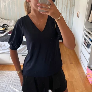 Mörkblå blus med v-ringning - En stilren mörkblå blus med v-ringad hals och puffiga ärmar. Blusen har en rak passform och är tillverkad i ett mjukt, lätt material som känns skönt mot huden. Perfekt att matcha med kjol eller jeans för en clean look. Denna går också att ha olika i ärmarna försökt få med på bild 2 & 3❤️ 