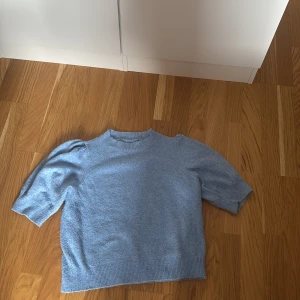 Stickad tröja - En stickad tröja med korta ärmar som är ny och har bara använts 3 gånger. Jag har klippt bort lappen för att jag tyckte att den var oskön. 