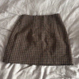 Rutig brun minikjol från MNG - Superfin rutig minikjol från MNG i bruna och beige toner. Den passar tyvärr inte längre och är i storlek xs. Den är högmidjad men är så snygg med en stickad tröja över. Jättesnyggt till hösten😍😍Då den inte passar längre kan jag inte ta bild med den på men sista bilden är en gammal bild med den på så ni kan se visionen❣️