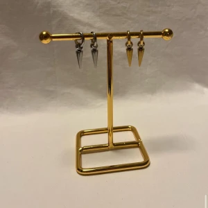 Örhängen med konformade hängen - Två par örhängen med konformade hängen, ett par i silverfärg och ett par i guldfärg. Snygg minimalistisk design som ger en edgy vibe. Passar perfekt för dig som gillar att sticka ut med detaljer. Metallfinish och enkel ring som håller hänget på plats.