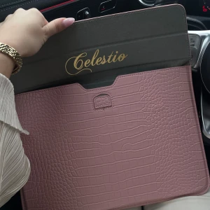 Celestio rosa datorväska  - Säljer en stilren datorväska från Celestio i ljusrosa med croco-mönstrad yta. Väskan är tunn och smidig, perfekt för att bära din laptop. Tillverkad i syntetmaterial med elegant finish och magnetisk stängning. Snygg accessoar för plugget eller jobbet.