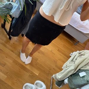 Svart kortkjol från NEU - Enkel svart kortkjol från NEU i stretchigt material. Kjolen har en rak passform med liten slits på sidan❤️