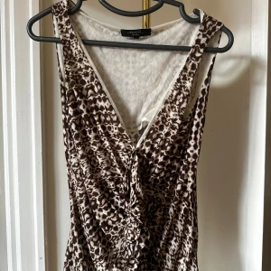 Leopardmönstrad MaxMara blus S - Snygg leopardmönstrad blus från MaxMara Weekend i bruna och beige toner. Djup v-ringning och omlottkänsla framtill. Perfekt för dig som vill sticka ut med ett coolt mönster och en feminin siluett.