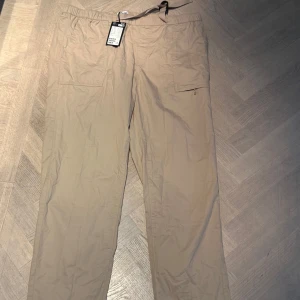 Beige cargopants med snörning - Snygga beige cargopants i tunn bomull från weekday, oanvända men lappen kvar, nypris 600. 
