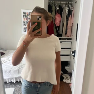 Vit stickad topp med öppen rygg från Zara - Superfin vit stickad topp från Zara med korta ärmar och en snygg öppen rygg med knytband. Modellen är lätt utsvängd nertill och har en mjuk, fluffig känsla. Perfekt att ha till hösten! Den är också oanvänd så den har kvar lapp, den är i storlek m men passar mig som har vanligtvis storlek s🥰