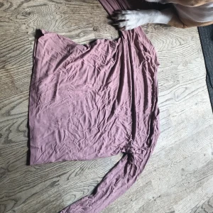 Rosa  långärmad topp - En mjuk och tunn långärmad topp i ljuslila färg. Tröjan har en enkel design med rund halsringning och är tillverkad i ett lätt material som känns skönt mot huden. Perfekt för lager-på-lager eller som en basic i garderoben.