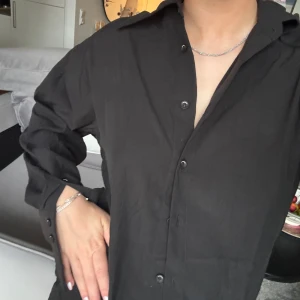 Oversized svart skjorta - Svart skjorta oversized så storlek s-l , slutar ungefär vid höften