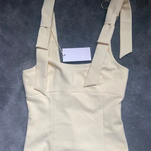 Gul topp (HELT NY) - Supersöt ljusgul linnetopp med breda axelband och knytband på axlarna.  Den är helt ny med lappen kvar ifrån zara i strl M🥰🥰 Skriv om ni vill ha fler bilder!💞💞💞