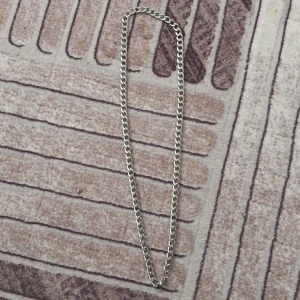 Kedjehalsband i silverfärg - Stilrent halsband med grov kedja i silverfärg. Klassisk design som passar till allt och ger en cool vibe. Länkarna är platta och blanka, vilket gör att halsbandet känns både modernt och tidlöst. Perfekt accessoar för att lyfta din outfit.
