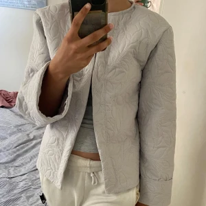 Ljusblå overshirt - Säljer en ljusblå overshirt med snyggt bladmönster. Jackan har raka, vida ärmar och stängs med en söt knytning framtill. Perfekt för lager-på-lager och ger en chill men ändå stilren vibe. Hemma sydd💗