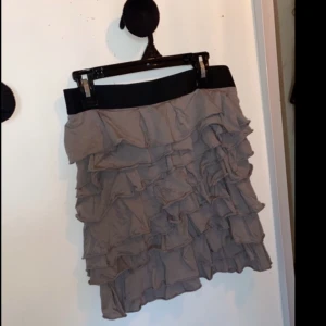 Mango - Volangkjol  - Superfin grå volangkjol från Mango med svart midjeresår & dragkedja baktill. Sparsamt använd och är i väldigt bra skick, inga skavanker överhuvudtaget. I strl S (36). Erbjuder rabatt vid köp av 2 eller fler produkter!