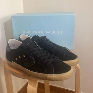 Svarta Philippe Model i svart mocka - Snygga Philippe Model i mocka. Skorna är i mocka och har snygga gulddetaljer! Skörna är i mycket fint begagnat skick och väldigt fräsha nu till våren. Box medföljer, skriv vid minsta funderingar! Pris kan diskuterad vis snabb affär!