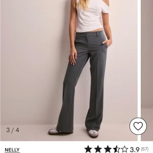 Grå kostymbyxor från Nelly - Stilrena grå kostymbyxor från Nelly med normal passform och raka ben. Byxorna har klassisk design med fickor i sidorna och hällor för bälte. Perfekta för en snygg och enkel look.