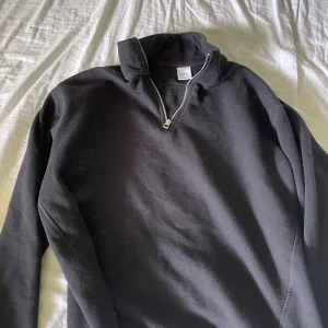 Svart halvzip tröja från Zara - Svart långärmad tröja från Zara med halv dragkedja och hög krage. Perfekt för lager-på-lager och enkel att matcha med olika outfits. Mjuk insida för extra komfort.