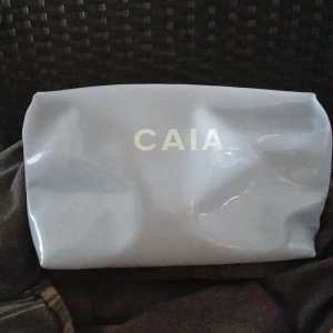 Ljusblå Stor Necessär Från CAIA 🌻 - Säljer en ljusblå stor necessär från CAIA med dragkedja upptill. Väskan är tillverkad i syntetmaterial/ plast  och har en stilren design med CAIA-loggan i vitt framtill och lila färg inuti . Perfekt för att förvara mycket  smink eller småsaker ! Den är oanvänd och finns inte att köpa längre hos CAIA ! Det finns två svaga nästan osynliga streck undertill som fanns där från början ! Säljs för 200 kr ! Köparen står för önskad frakt och inga återköp 🌻